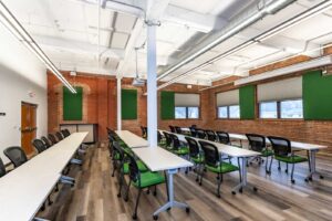 An event space with green chairs and tables