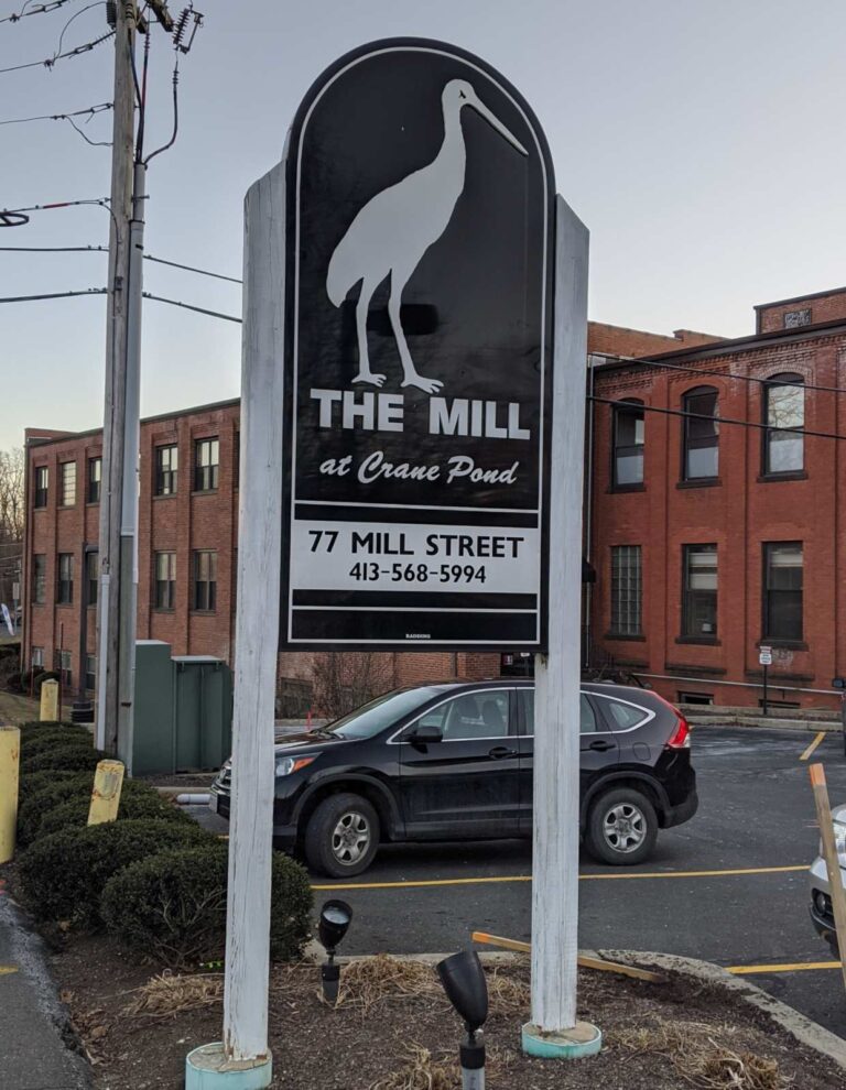 A sign board with The Mill at Crane Pond logo